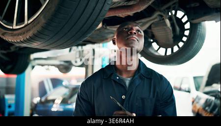 Black man, mechanic and inspection with car in workshop for automotive repair, fix or diagnostics. Male person, engineer and checking vehicle for road Stock Photo