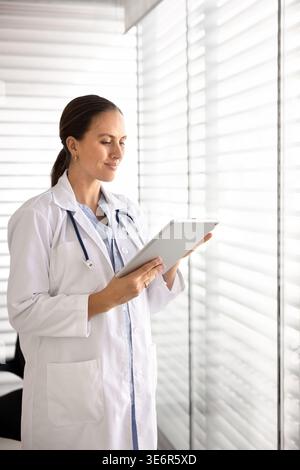 Female doctor working on digital tablet in hospital office Stock Photo
