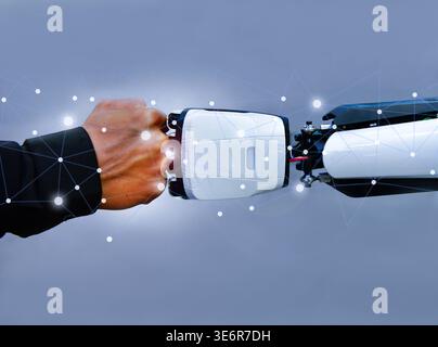 Human and robot fist bump against digital network background, representing future collaboration between man and artificial intelligence Stock Photo