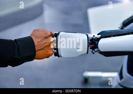 Human and robot fist bump against digital network background, representing future collaboration between man and artificial intelligence Stock Photo
