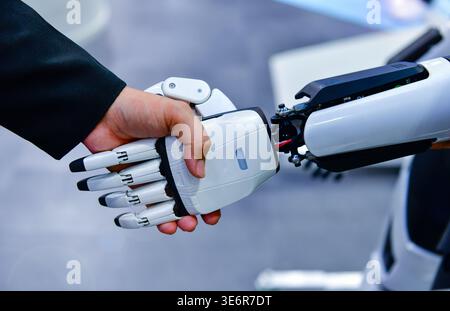 Robot and human handshake representing artificial intelligence collaboration and future technology. Stock Photo