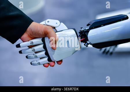 Robot and human handshake representing artificial intelligence collaboration and future technology. Stock Photo