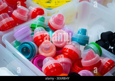 Different plastic products. Products made of multi-colored plastic. Models set of various products made of plastic. Multicolored objects. Models plastic bottle caps for sealing containers Stock Photo