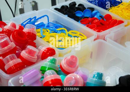 Different plastic products. Products made of multi-colored plastic. Models set of various plastic products. Models plastic bottle caps for sealing containers, handles for carrying PET bottles, caps Stock Photo