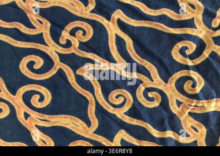 Dark blue fabric features swirling golden patterns Stock Photo