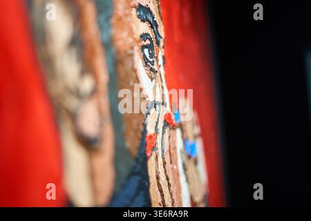 Close-up side view of an oil painting on canvas, showcasing thick impasto brushstrokes and textured paint application. The artwork depicts a portrait Stock Photo