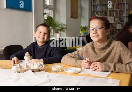 Children learn to paint Easter eggs using wax according to the ancient Ukrainian tradition Stock Photo