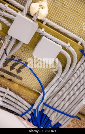 Electrical wiring in conduits with junction boxes in unfinished wall interior, home renovation system. Concept wiring installation Stock Photo