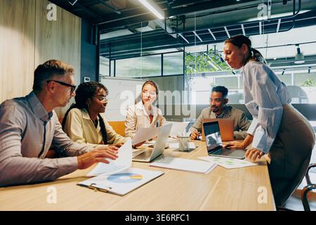 Team engaged in lively discussion analyzing data and planning ahead Stock Photo