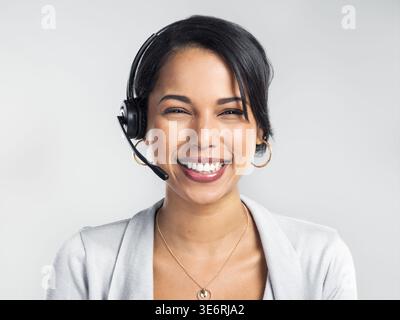 Portrait, customer service and woman in studio, headset and professional on white background. Person, help desk and employee with consultation, call Stock Photo