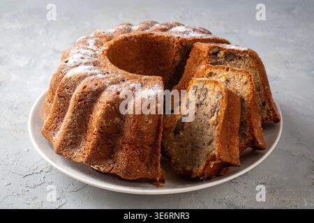 Homemade Sliced Bundt Cake with Walnuts and Cinnamon Sprinkled with Powdered Sugar Stock Photo