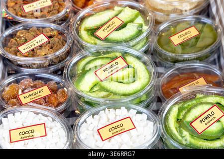 Assorted packaged dried fruits, including pomelo, coconut, kumquat and grapes, displayed at a local market in Italy Stock Photo