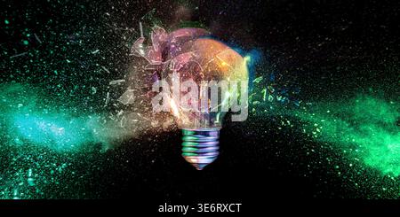 Lightbulb exploding into colorful dust Real shot Stock Photo