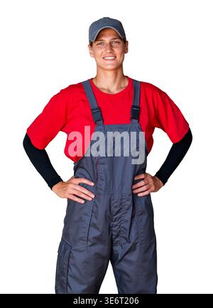 Smiling female worker in grey overalls and red t-shirt standing with hands on hips, isolated on a white background. Stock Photo