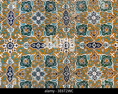 A tile pattern with a yellow and green background. The tiles are arranged in a way that creates a sense of movement and flow. The colors and shapes of the tiles create a sense of harmony and balance Stock Photo