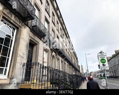 Edinburgh, Scotland, UK - February 16, 2026: Street view of Georgian stone facades, ornate iron railings, pedestrians and a low emission zone sign in Stock Photo