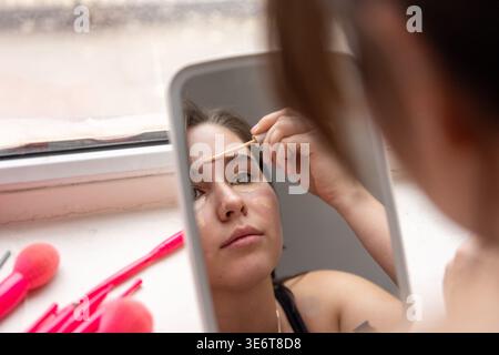 Close up of woman applying face concealer Stock Photo
