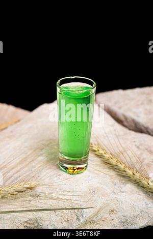 Green absinthe alcoholic drink in shot glass isolated on black background. Stock Photo
