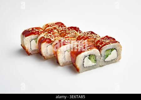 Eight tempura sushi rolls in crispy batter with cream cheese and cucumber filling, topped with red teriyaki sauce and sesame seeds, isolated on white Stock Photo