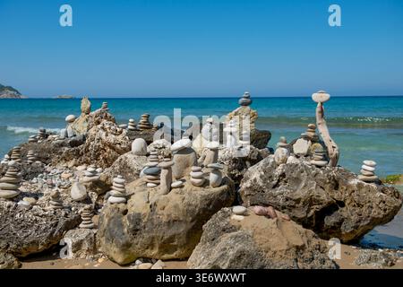 Commercial: Zen stones stacked on the rocks at Arillas Beach in Corfu. Balancing pebbles by the Ionian Sea, Greece. Captured on July 9, 2023. Stock Photo