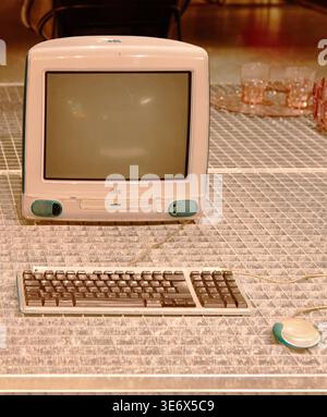Brussels, Belgium - October 06, 2025: the iconic all-in-one desktop computer. Apple iMac G3 computer with a keyboard and mouse showcased on a grid-pat Stock Photo