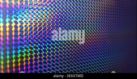 Holographic texture reflecting vibrant rainbow light in a shimmering abstract pattern Stock Photo