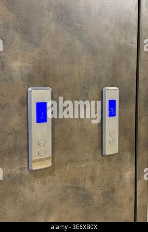 Elevator control panel on a metallic wall with illuminated digital displays, concept of technology. Mobile photo Stock Photo