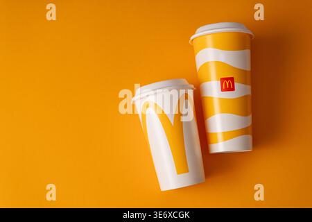 Two McDonald's Coffee Cups with Golden Arches Logo on yellow Background Minimalist Composition logo copy space Stock Photo