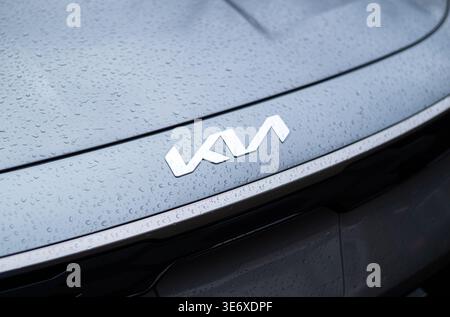 Kyiv, Ukraine. April 3, 2026. Close-up of a silver Kia logo on a grey car hood covered in raindrops. Stock Photo