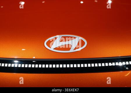 Zurich, Switzerland, October 10, 2025. Detail shot of the silver Hyundai logo and pixelated horizon light bar on a bright orange car at the Zurich Aut Stock Photo