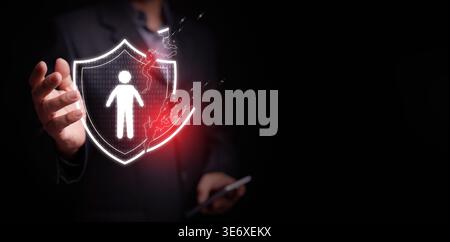 Personal data breach and cybersecurity concept. Broken shield protecting human figure is attacked, held by a businessman. Identity theft protection, w Stock Photo