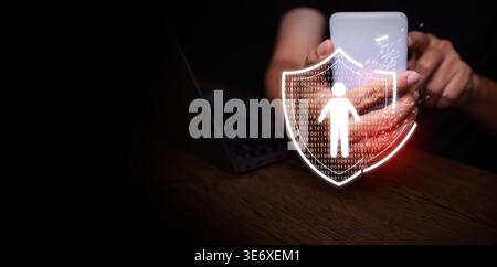 Personal data breach and cybersecurity concept. Broken shield protecting human figure is attacked, held by a man using smartphone. Identity theft prot Stock Photo