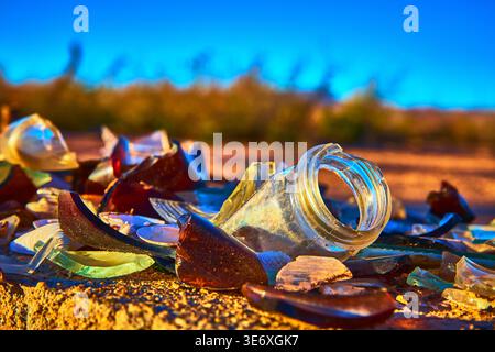 Broken Glass Bottle Shards on Desert Ground at Golden Hour in Nevada Ghost Town Stock Photo
