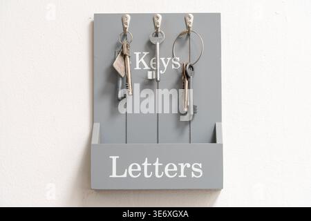 Keys hanging on hooks with gray labeled storage board Stock Photo
