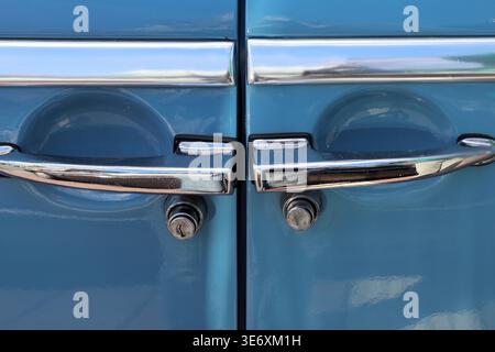 Close-up of two chrome door handles with locks on a blue vintage car Stock Photo