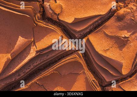 Cracked Earth. An arid landscape with cracked, dry earth patterns in a warm orange hue Stock Photo