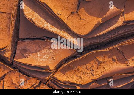 Cracked Earth. An arid landscape with cracked, dry earth patterns in a warm orange hue Stock Photo