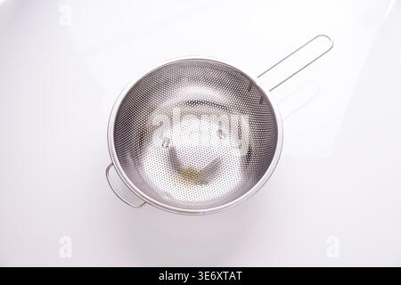 Top View of Stainless Steel Colander on White Background Stock Photo