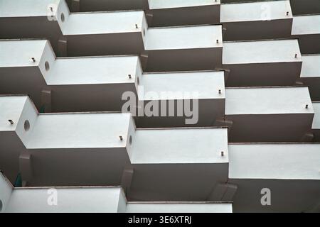 Minimalist white apartment balconies with geometric patterns and repetitive architectural design under soft daylight. Stock Photo