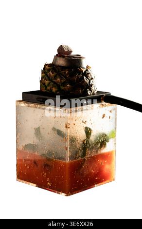 Creative hookah with pineapple top charcoal and transparent acrylic base with herbs and layered liquids isolated on white background Stock Photo