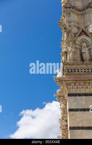 Close-up architectural detail of Siena Cathedral facade against blue sky with clouds in Siena, Tuscany, Italy Stock Photo