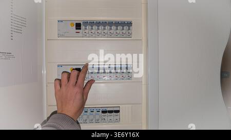 Hand switching circuit breaker in electrical panel, home electricity control Stock Photo