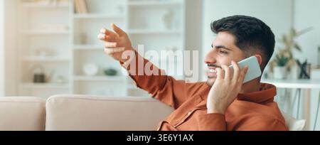 Man Talking on Phone While Sitting in Living Room During Day Stock Photo