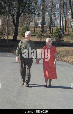 Elderly couple taking a walk walking outside on sunny day, Pennsylvania USA Stock Photo