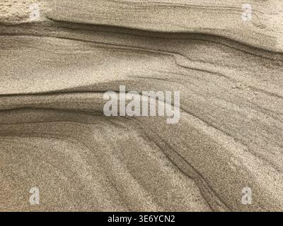 View of layers of sand sculpted by wind and water, creating a textured landscape of natural patterns and subtle color variations, De Cocksdorp, Noord- Stock Photo