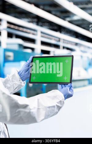 Isolated screen tablet used by microchip designer inspecting semiconductor production infrastructure, optimizing photolithography. Man trialing silicon wafers materials using chroma key device, close up Stock Photo