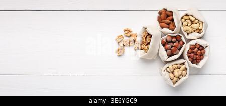 Mix of nuts in burlap bags on wooden background Stock Photo