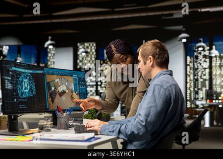 Diverse team of engineers using artificial intelligence to design a floor plan, working together with neural networks and computer aided apartment layout on architectural software. Stock Photo