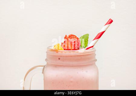 A tall, thin glass displaying layers of passion fruit, orange, and pomegranate juice, creating a natural gradient inside—perfect for a textured photo Stock Photo