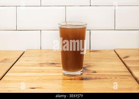 Forest fruit juice in a tall, wide glass, with blackberries and blueberries submerged and a light foam peeping at the surface Stock Photo